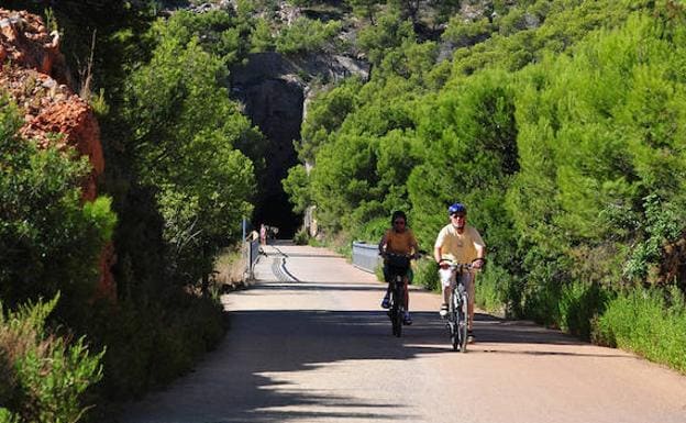 Dos ciclistas recorriendo la ruta de la Vía Verde del Mar. 