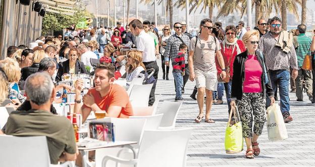 Residentes y turistas en las terrazas y el paseo de la playa de San Juan, en Alicante. 