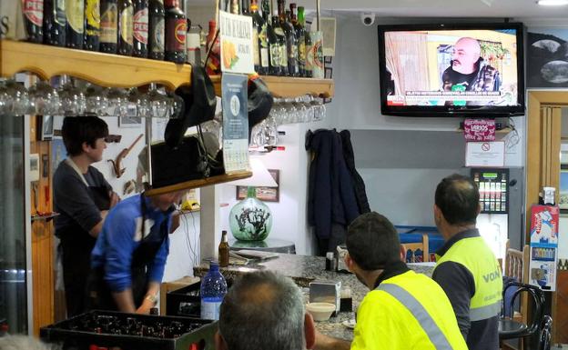 Clientes observando la televisión de un local. 