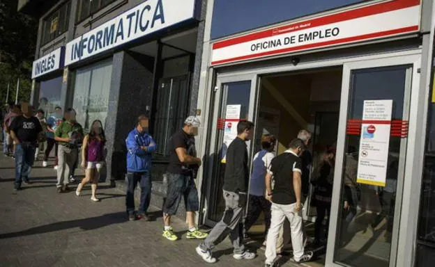 Gente haciendo cola para entrar en una oficina de empleo. 