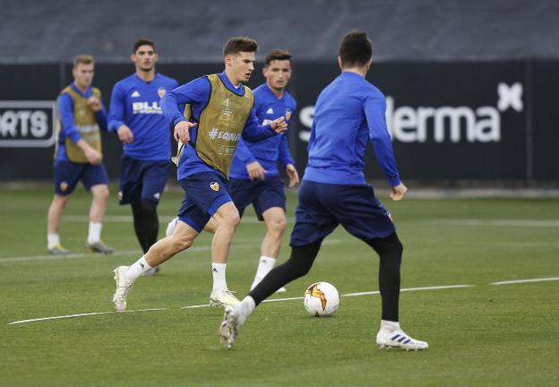 Santi Mina avanza con el balón durante un entrenamiento del Valencia.  