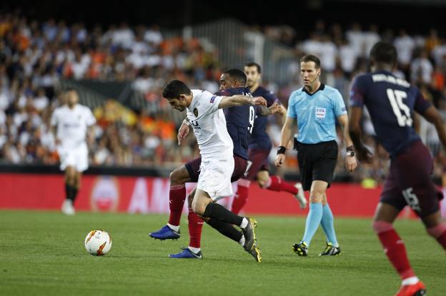 Guedes intenta ganar la partida a Lacazette. 