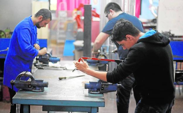 Varios estudiantes de FP trabajan en uno de los talleres de su centro.