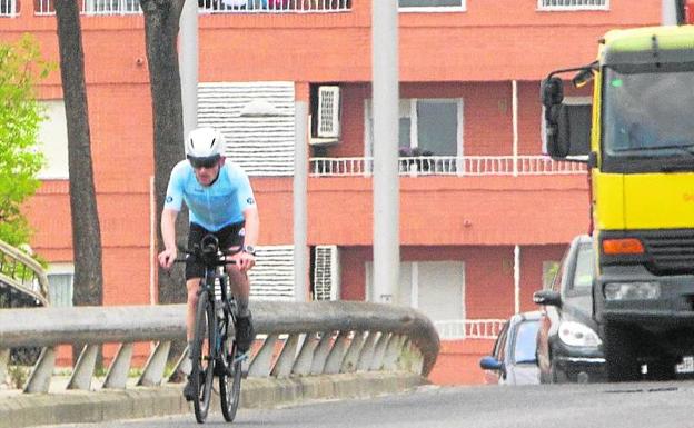 Un ciclista, seguido de varios coches en Burjassot.