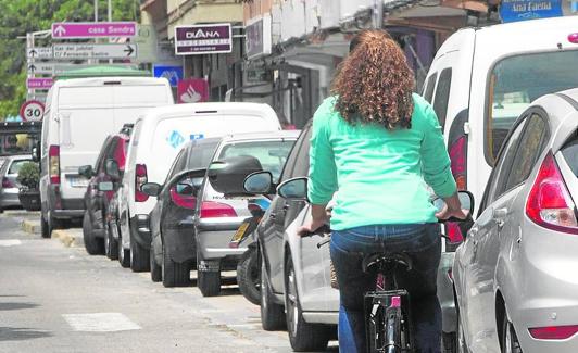 Una ciclista circula por el carril bici.