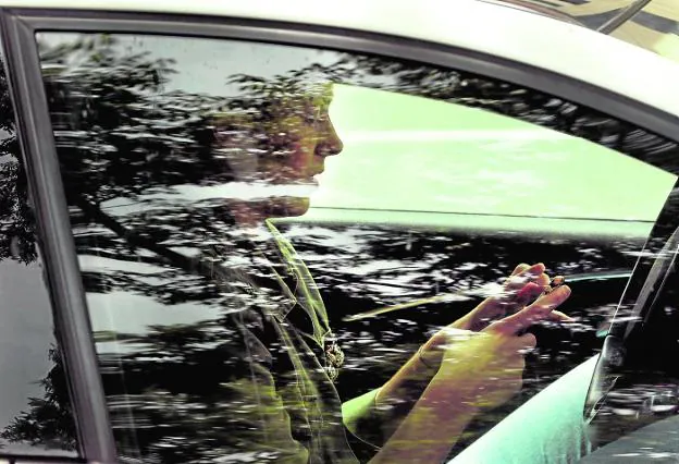 Una persona manipula el teléfono móvil en su vehículo. 