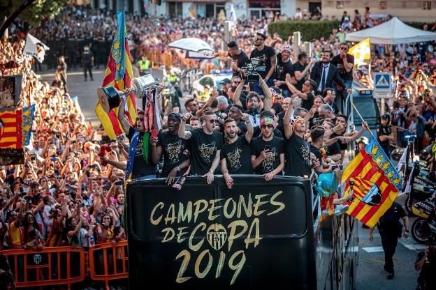 Los jugadores
celebran el título
en unas calles de
Valencia repletas
de gente. 