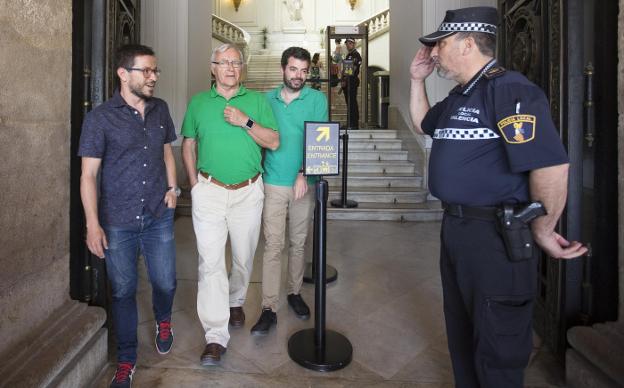 Un agente saluda al alcalde Joan Ribó, ayer en la puerta del Ayuntamiento. :: 