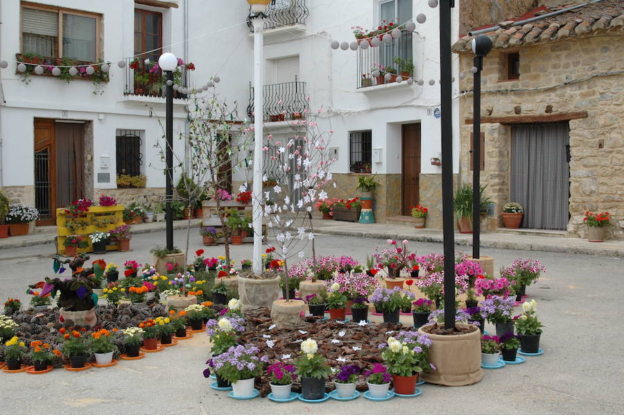 Los aromas y colores de las flores se han adueñado de Aras de los Olmos (Valencia). Durante la primavera, esta localidad situada Los Serranos cubre sus calles, fachadas con cientos de plantas y arte efímero. La exposición de las propuestas presentadas en «Aras en flor» se podrá visitar hasta el 30 de junio Los diseñadores de paisajes han tenido que defender la sostenibilidad, belleza y creatividad de la propuesta. Además de combinar flores y plantas con materiales del entorno utilizados históricamente por los vecinos y vecinas. Esta pequeña localidad del interior de la Comunitat Valenciana aguarda entre montes como un remanso de paz que fue poblado por íberos, romanos y árabes, Incluso, formó parte de la Orden de Montesa en 1318. Y todas estas culturas se han quedado guardadas entre sus callejuelas. 