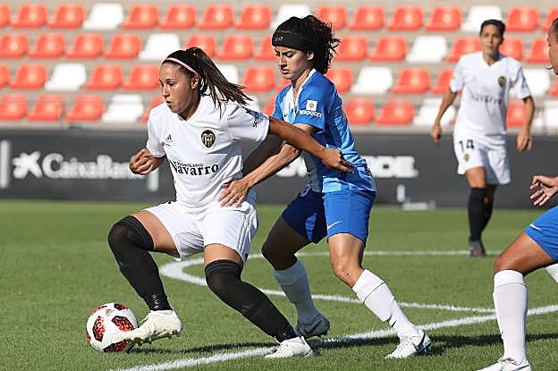 Mari Paz protege el balón ante una futbolista contraria, durante un partido en el estadio Antonio Puchades. 