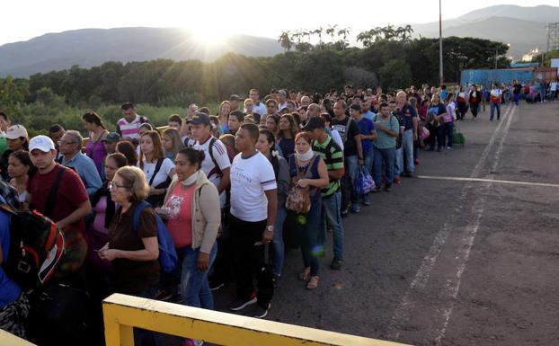 Cientos de personas hacen cola para cruzar de Venezuela a Colombia. 