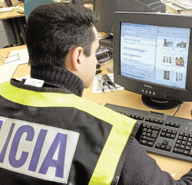 Un policía investiga datos en un ordenador. 