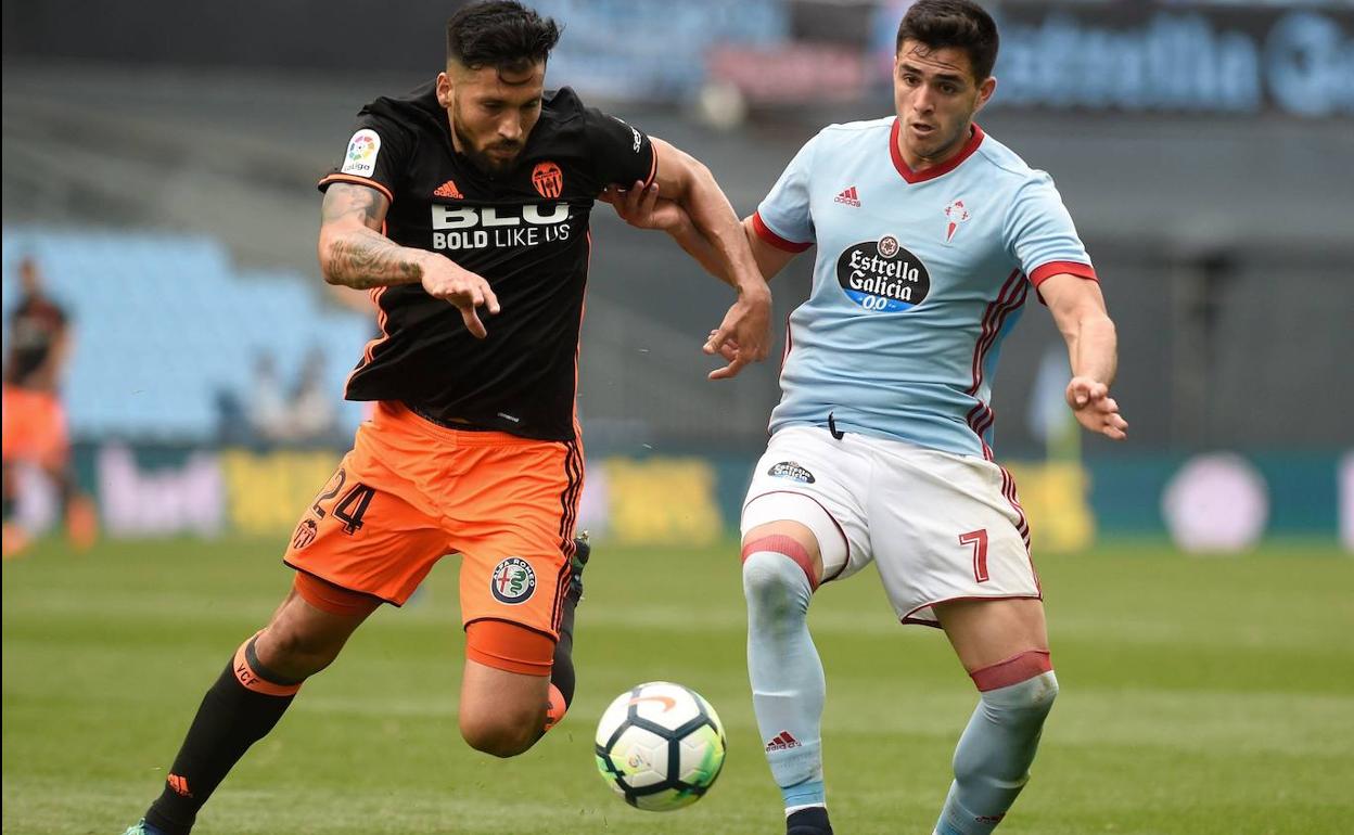 Garay y Maxi Gómez luchan por el balón.