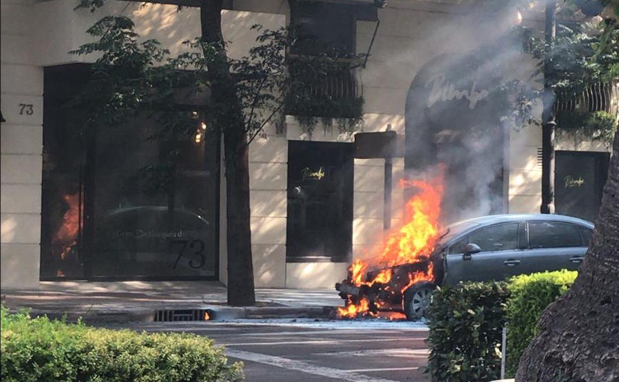 El coche, en llamas, en la Gran Vía de Valencia.