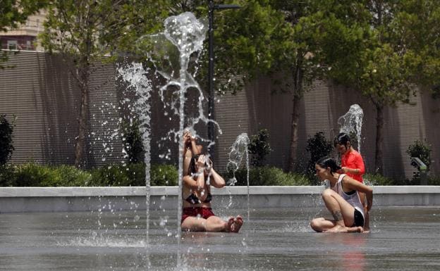 Imagen principal - Personas bañándose en las fuentes del Parque Central de Valencia.