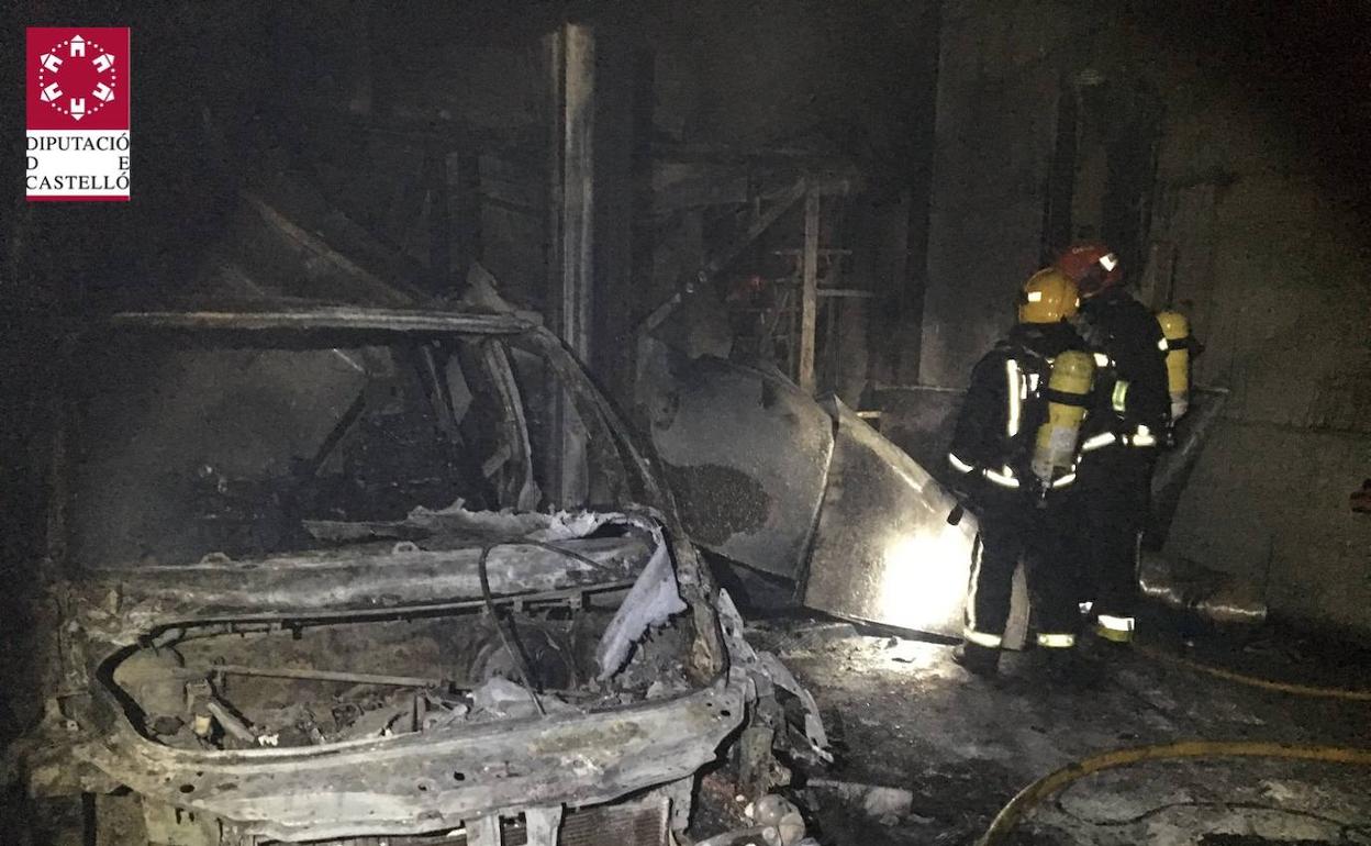 Uno de los coches del interior del taller calcinado por el fuego. 