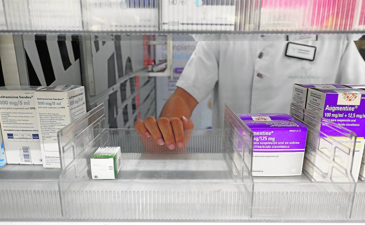 Una farmacéutica busca medicinas en el almacén.