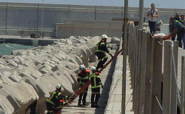 Bomberos, guardias y personal de salvamento, en el rescate del cuerpo. 