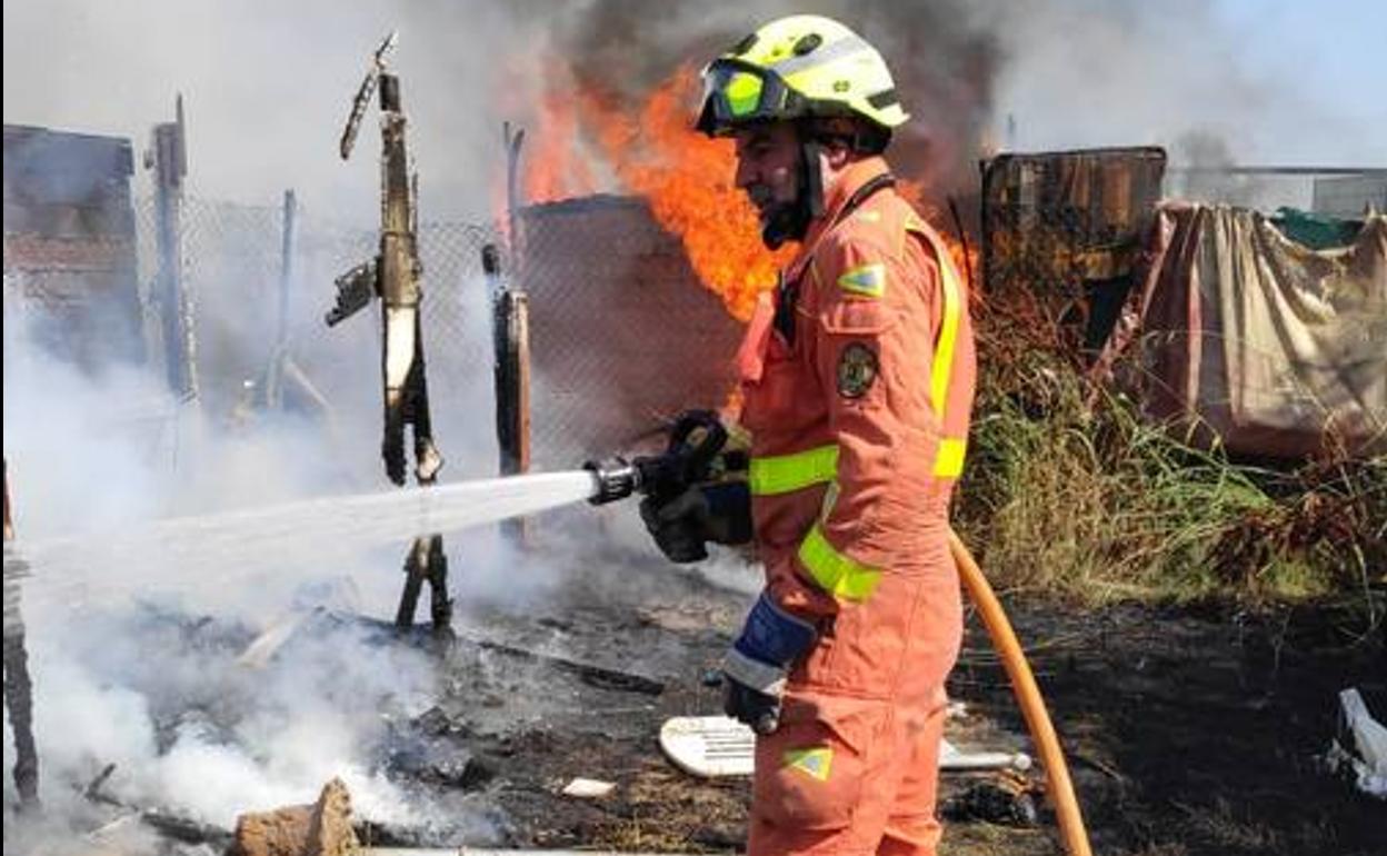 Un bombero, apagando el fuego ocasionado por el camión.