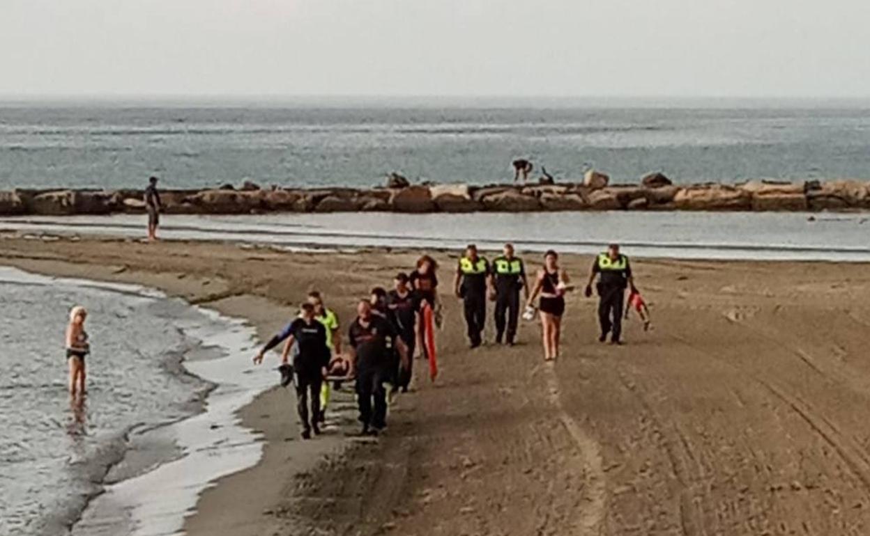 Los efectivos trasladan a la joven en una camilla tras sacarla del agua. 