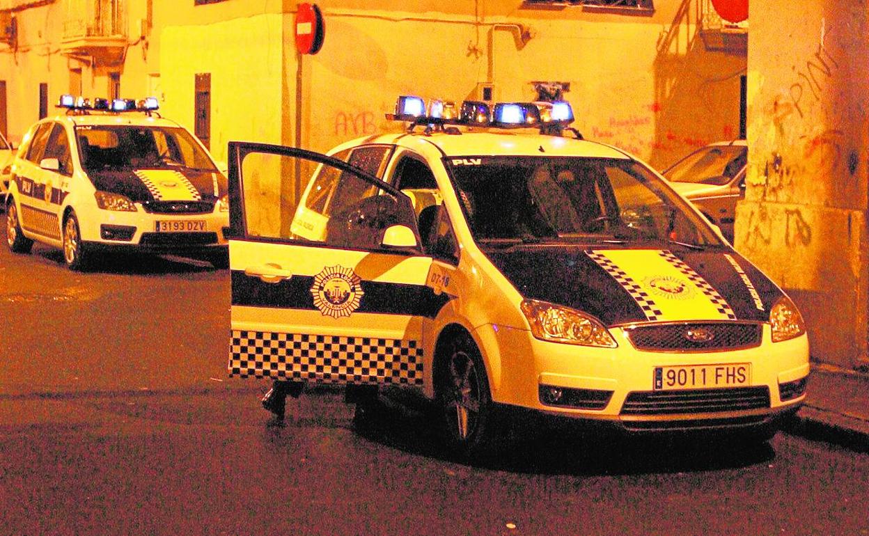 Dos vehículos de la Policía Local en una calle del distrito Marítimo.