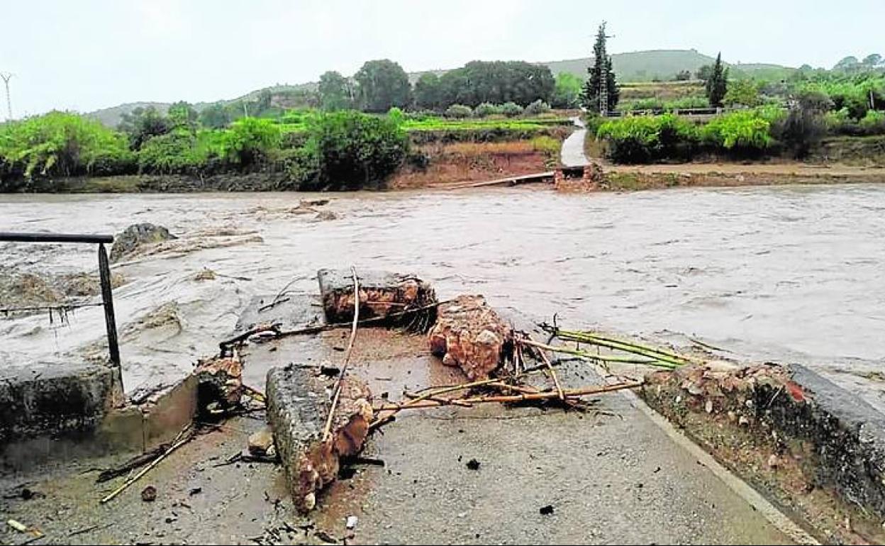 El agua arrastra las piedras del antiguo puente.