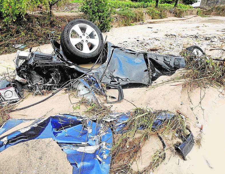 Un coche destrozado tras ser arrasado por el agua, en Moixent.