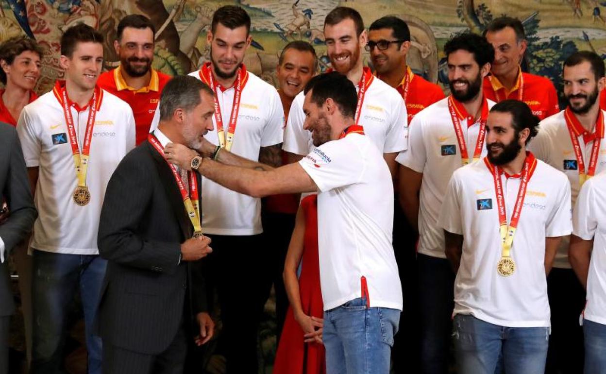 Rudy Fernández, capitán de España, cuelga la medalla al rey Felipe.