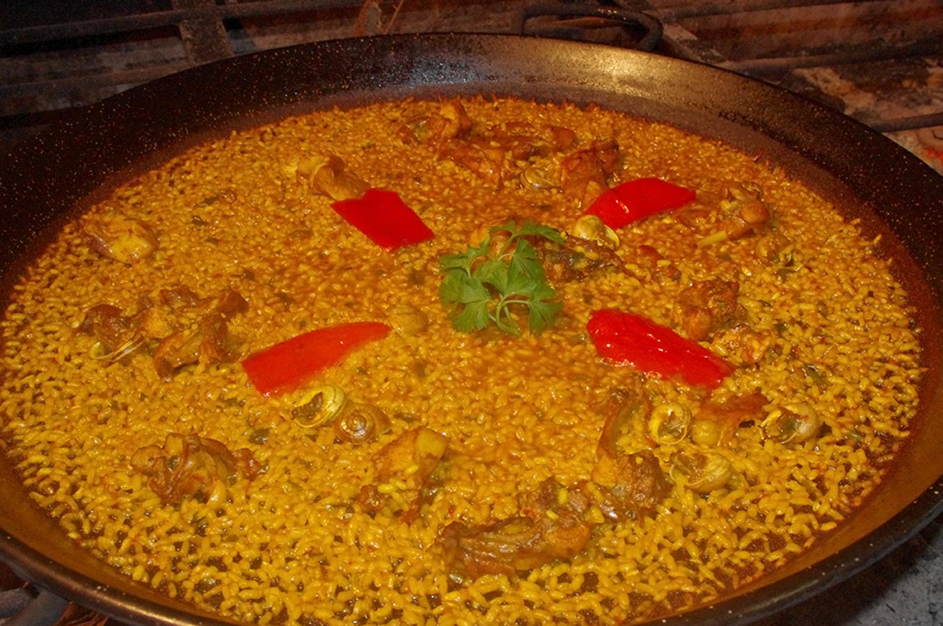 ARROZ DE SARMIENTO DE CONEJO Y SERRANAS. Noelia Pascual y su hermana Lidia del Restaurante Cachito enclavado en el Campo de Elche están emprendiendo nuevas perspectivas de futuro, pero teniendo siempre presentes, la tradición y sabiduría de sus antecesoras y el gusto por el origen. Han realizado show cookings y master class sobre los tradicionales arroces alicantinos de sarmiento, una técnica de cocción a gran fuego muy espectacular que requiere gran pericia.