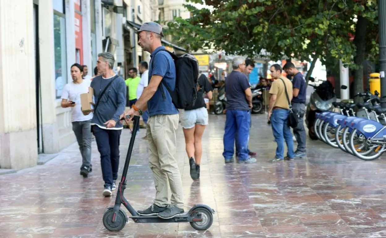 Un usuario de patinete eléctrico por la plaza del Ayuntamiento.