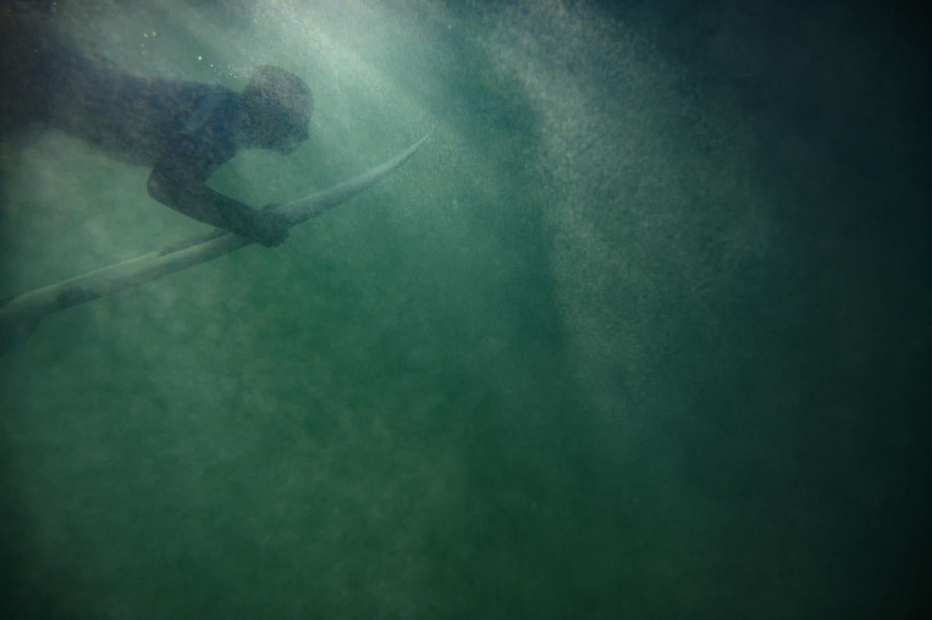 Un surfista rema debajo de una ola en Unstad.