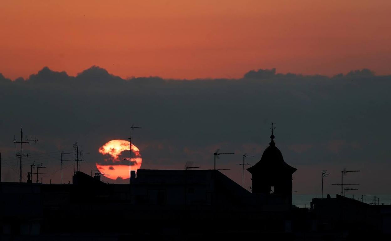 Amanece entre nubes sobre los tejados de Burjassot. 