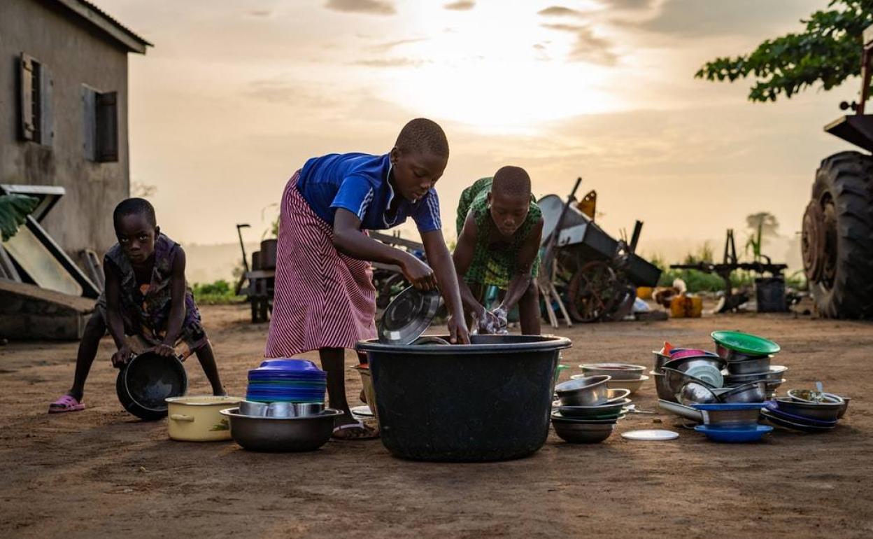 Dos niñas y su hermano pequeño trabajando en Togo.