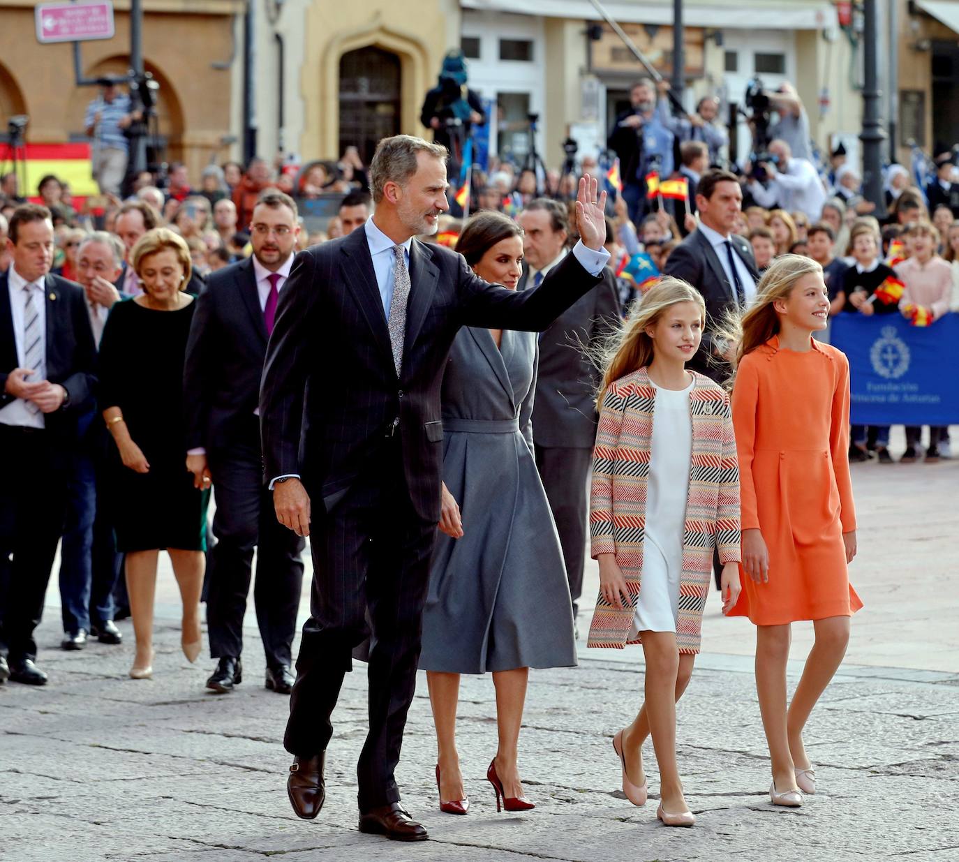 La Familia Real al completo ha llegado este jueves a Oviedo para iniciar su visita oficial con motivo de los Premios Princesa de Asturias de 2019. En esta edición, la princesa Leonor pronunciará el que será su primer discurso en una ceremonia de entrega de los Premios. Lo hará a los trece años, la misma edad que lo hizo su padre, el Rey Felipe, en 1981. Varios cientos de personas, con banderas de España y de Asturias, y la tradicional banda de gaiteros han dado la bienvenida esta tarde a la heredera durante primera visita a la capital asturiana, que ha realizado junto a los reyes y la infanta Sofía.