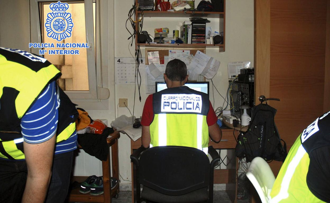 Fotografía facilitada por la Policía Nacional, que muestra a los agentes revisando el material de un pederasta.