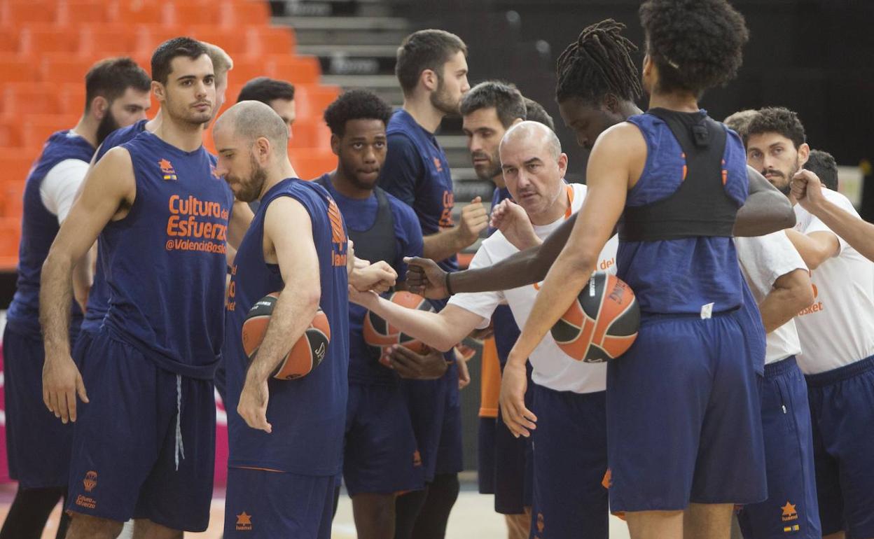 Los jugadores y el cuerpo técnico del Valencia Basket hacen el saludo de grupo tras un entrenamiento 