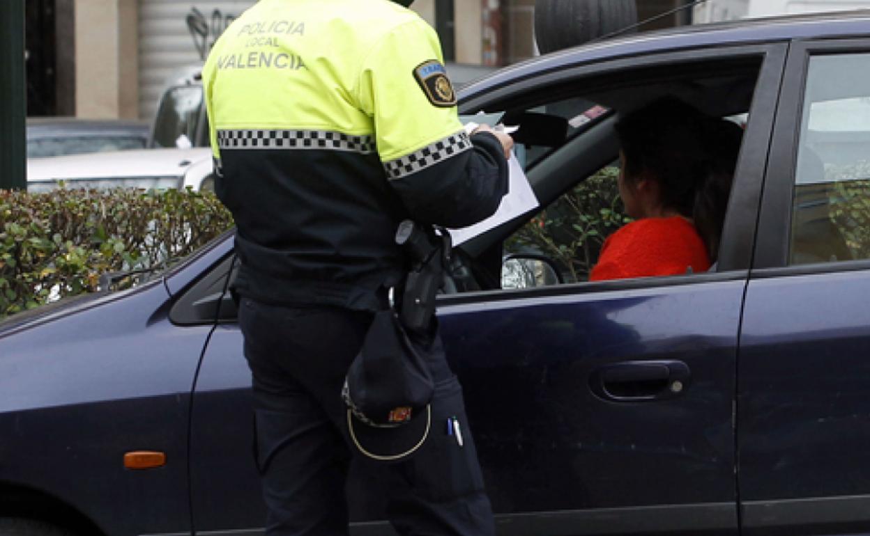 Un policía local, poniendo un multa, en una imagen de archivo.