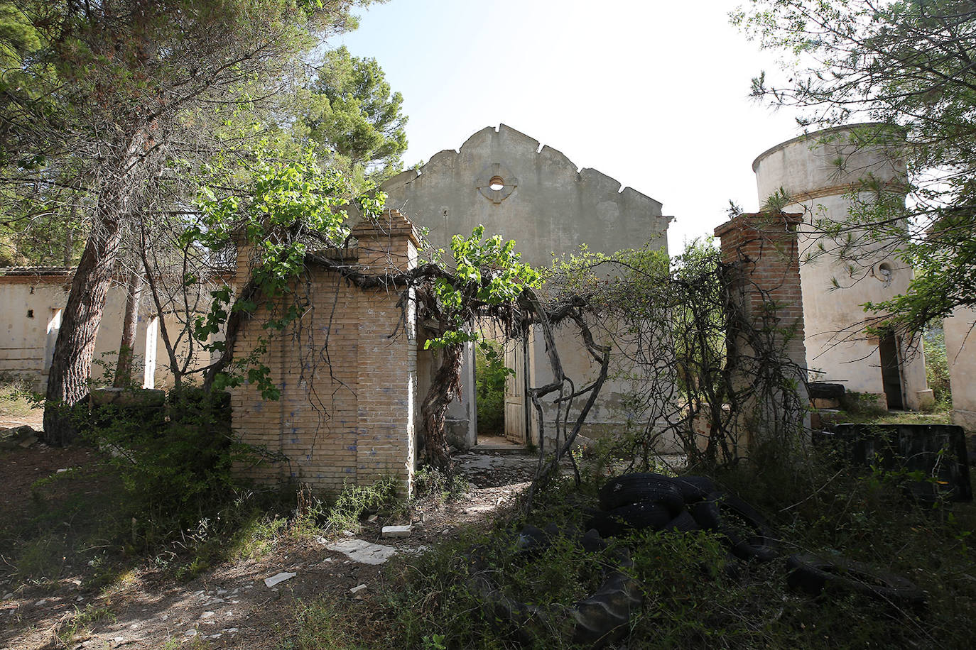 La cementera de Benagéber (Valencia) | La enorme construcción todavía se contempla desde lo lejos, como un colosal castillo de hormigón entre agua y maleza. Construida en la década de los cuarenta, fue gestionada por la misma empresa que se encargó del embalse, Portolés y Cía, que se convertiría en una de las principales compañías de obras públicas tras la Guerra Civil. La construcción del pantano de Contreras también corrió a cargo de esta firma, prueba de su estrecha colaboración laboral con el gobierno franquista. En aquella época, la mayoría de los habitantes de Benagéber eran los trabajadores de las obras del embalse y la cementera. Por ello, cuando en 1955 finalizaron los trabajos para la formación del pantano, la mayoría de la población emigró y el lugar quedó sumido en la escalofriante quietud que, a día de hoy, le sigue caracterizando. 