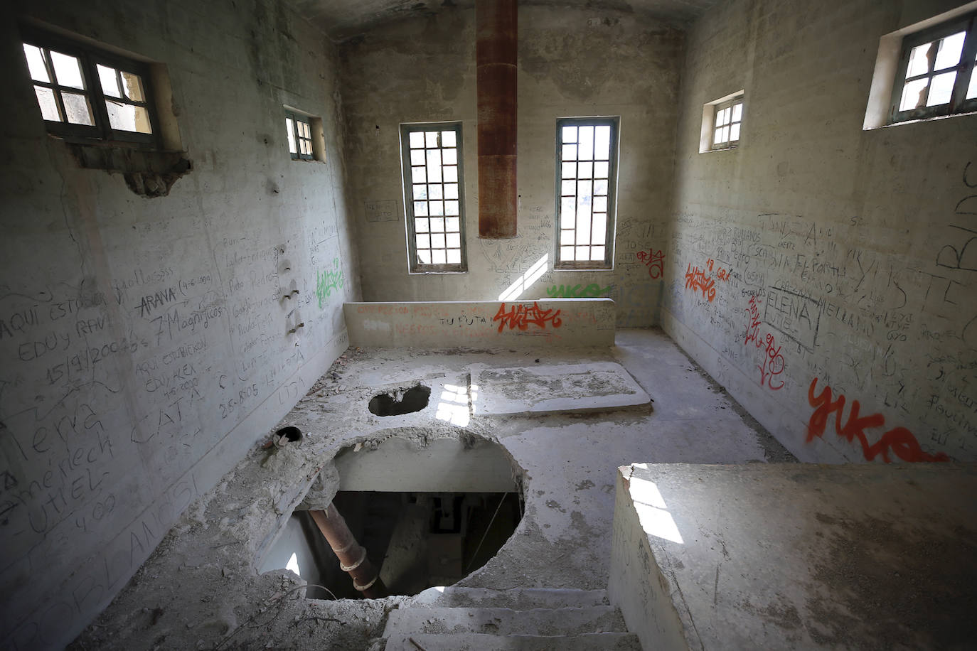 La cementera de Benagéber (Valencia) | La enorme construcción todavía se contempla desde lo lejos, como un colosal castillo de hormigón entre agua y maleza. Construida en la década de los cuarenta, fue gestionada por la misma empresa que se encargó del embalse, Portolés y Cía, que se convertiría en una de las principales compañías de obras públicas tras la Guerra Civil. La construcción del pantano de Contreras también corrió a cargo de esta firma, prueba de su estrecha colaboración laboral con el gobierno franquista. En aquella época, la mayoría de los habitantes de Benagéber eran los trabajadores de las obras del embalse y la cementera. Por ello, cuando en 1955 finalizaron los trabajos para la formación del pantano, la mayoría de la población emigró y el lugar quedó sumido en la escalofriante quietud que, a día de hoy, le sigue caracterizando. 