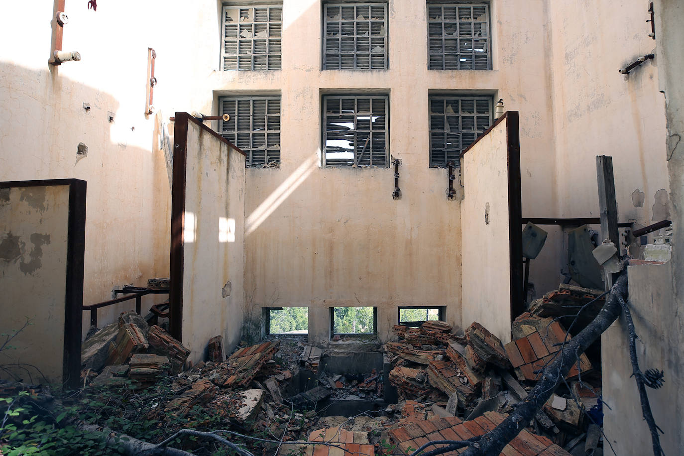 La cementera de Benagéber (Valencia) | La enorme construcción todavía se contempla desde lo lejos, como un colosal castillo de hormigón entre agua y maleza. Construida en la década de los cuarenta, fue gestionada por la misma empresa que se encargó del embalse, Portolés y Cía, que se convertiría en una de las principales compañías de obras públicas tras la Guerra Civil. La construcción del pantano de Contreras también corrió a cargo de esta firma, prueba de su estrecha colaboración laboral con el gobierno franquista. En aquella época, la mayoría de los habitantes de Benagéber eran los trabajadores de las obras del embalse y la cementera. Por ello, cuando en 1955 finalizaron los trabajos para la formación del pantano, la mayoría de la población emigró y el lugar quedó sumido en la escalofriante quietud que, a día de hoy, le sigue caracterizando. 