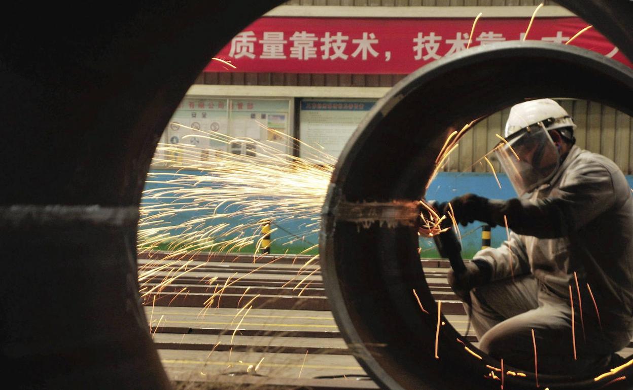 Un operario trabajando en un oleoducto en China.