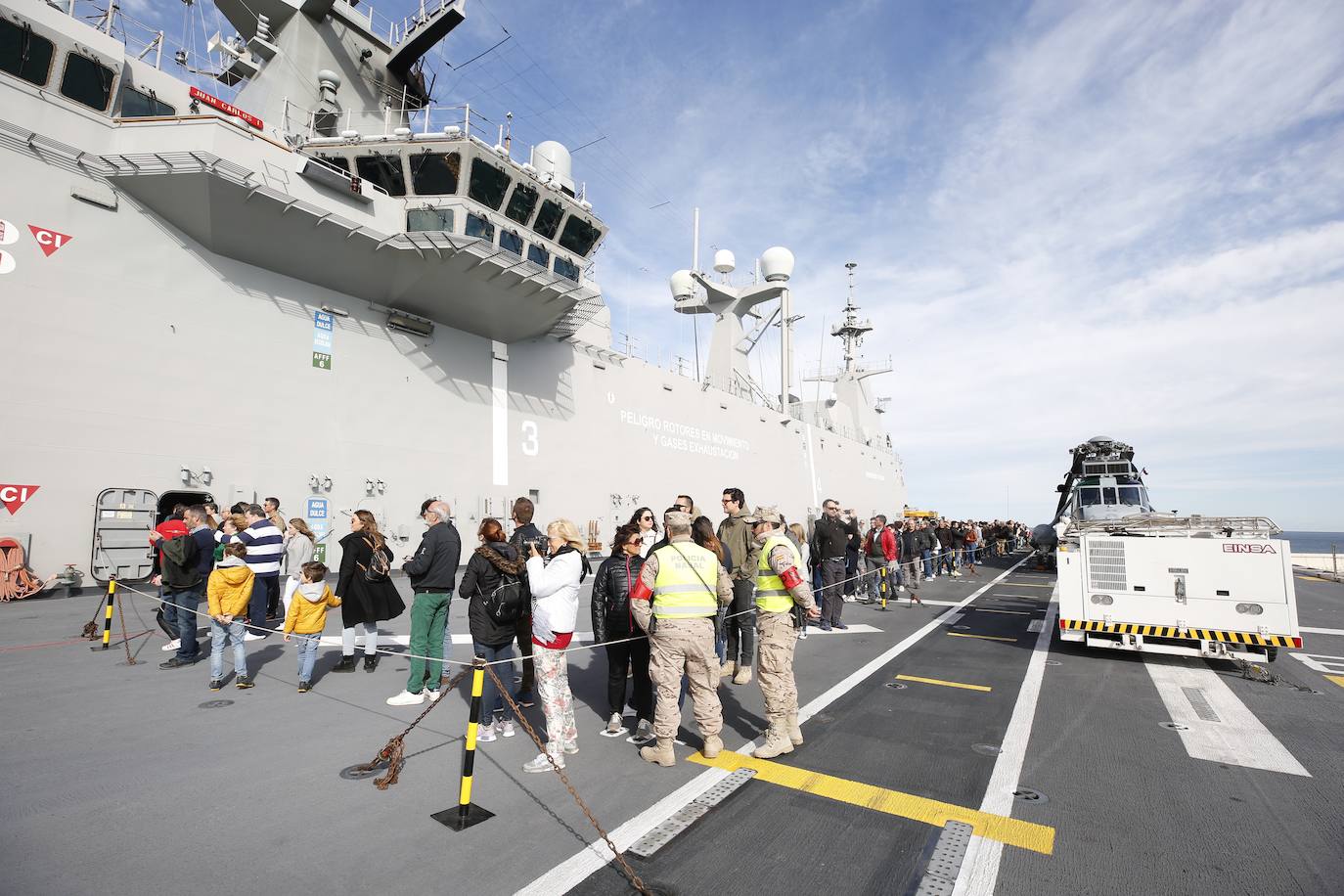 Cientos de personas han hecho largas colas durante la mañana de este sábado para poder subir y descubrir el interior del buque insignia de la Armada, el 'Juan Carlos I'. El portaaviones está atracado durante este fin de semana en el puerto de Valencia y este sábado se celebraba una jornada de puertas abiertas para poder subir y ver cómo es la vida dentro de un barco con más de 200 metros de eslora. 