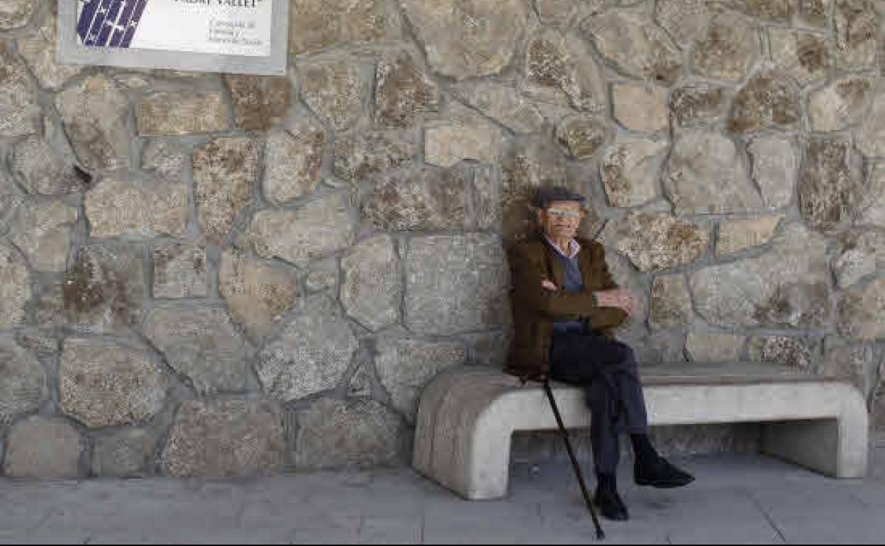 Un jubilado, sentando en un banco.