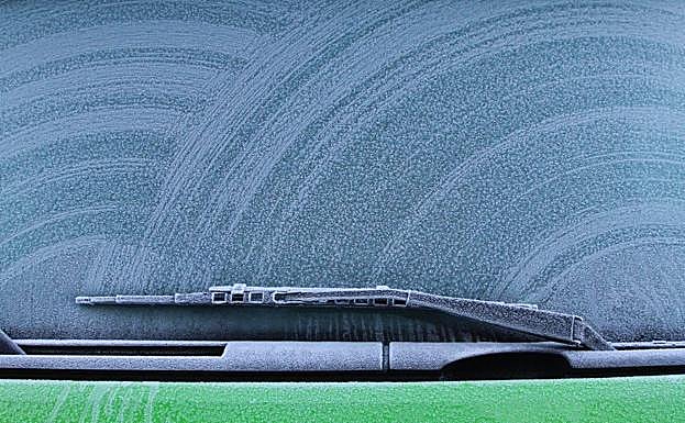 Un limpiaparabrisas y un cristal con escarcha.