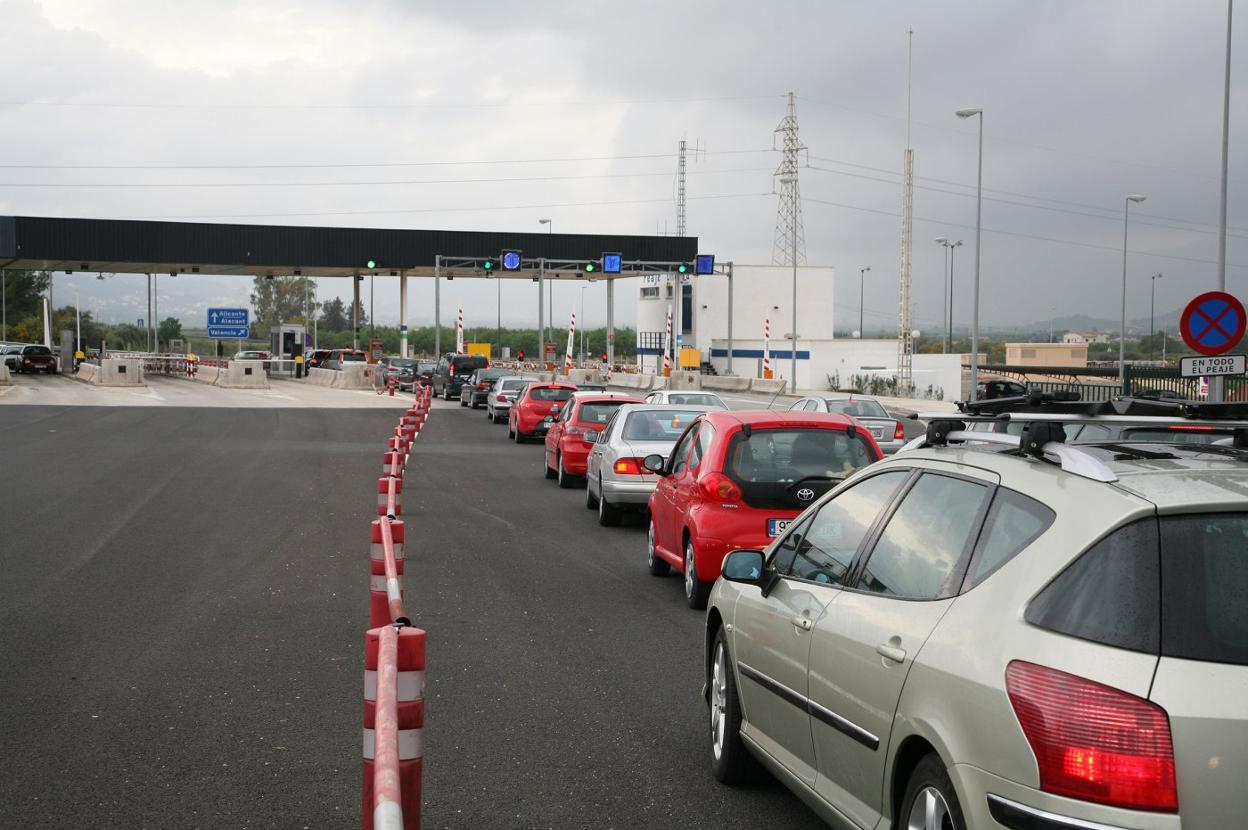 Una fila de coches espera en el peaje de Ondara. 