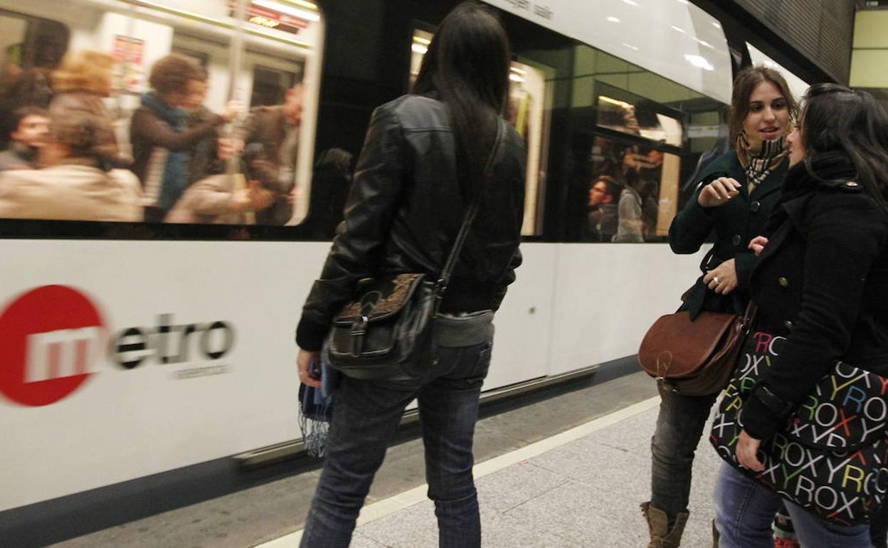 Varios pasajeros en la estación de metro de Colón. 