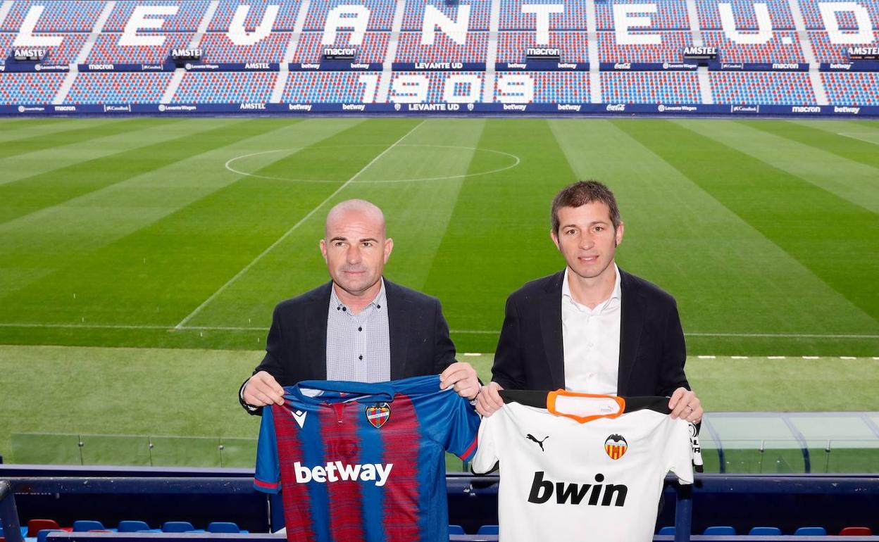 Paco López (izquierda) y Albert Celades posan con las camisetas de sus equipos en la grada de tribuna del estadio Ciutat de València