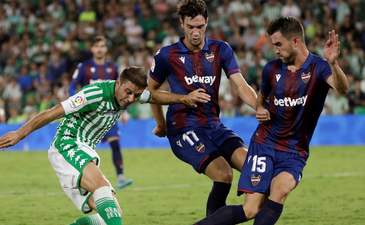 Los jugadores del Levante UD, Nikola Vukcevic y el defensa Sergio Postigo, disputan un balón con Joaquín, del Betis. 