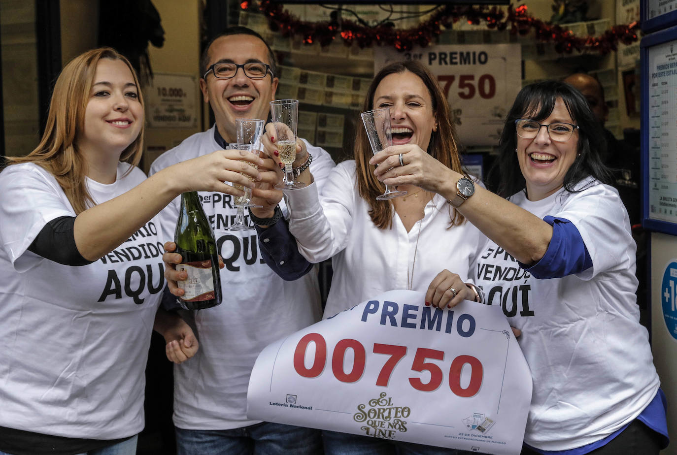 Trabajadores de la administración de la Avenida del Puerto, 173, en Valencia, celebran que han distribuido parte del tercer premio (00750) del Sorteo Extraordinario de la Lotería de Navidad 2019.