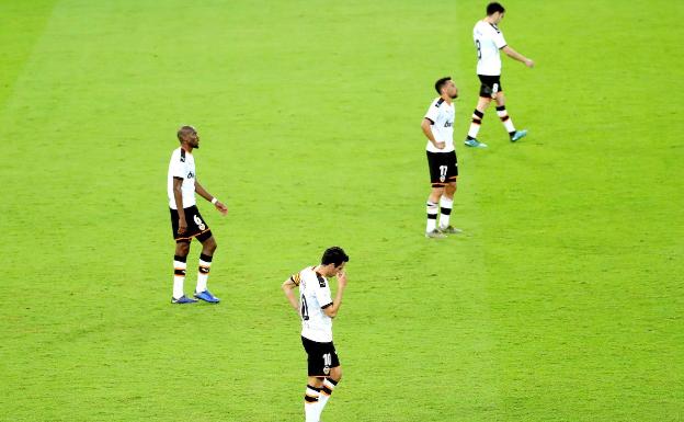 Los futbolistas del Valencia, después de encajar el segundo gol del Real Madrid